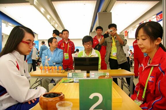 ▲ 2010年亚运会，中国台湾棋手黑嘉嘉与朝鲜棋手赵新星在对局。当时，朝鲜队的教练是李凤日。