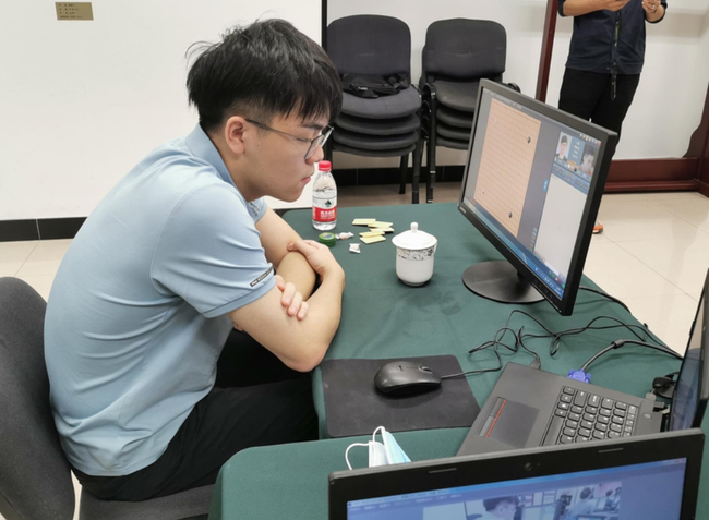应氏杯第三轮,柯洁面对电脑,桌旁放着糖和风油精。